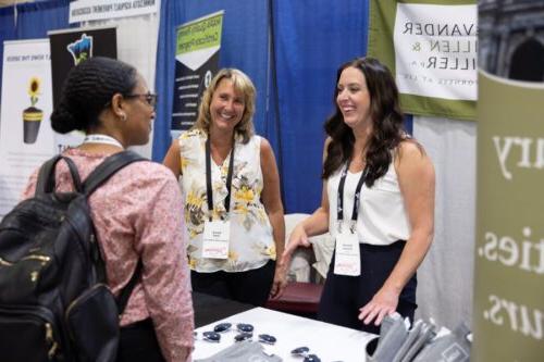 Vendors are shown speaking with a 2023 Annual Conference attendee.